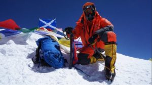 Image, person sitting at the top of Mount Everest in the snow